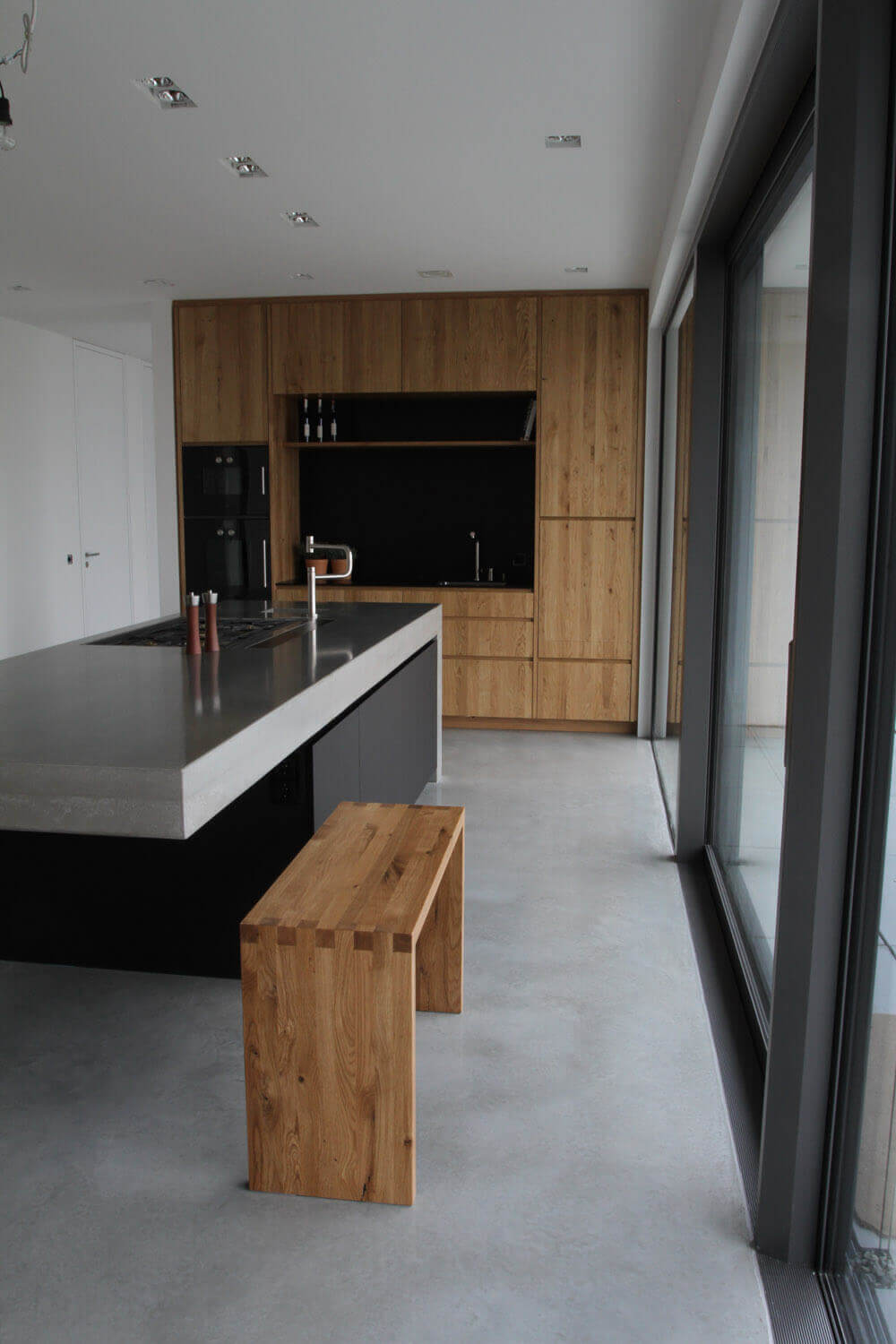 Moderne Betonküche kombiniert mit Holz und Elektrogeräten von Gaggenau