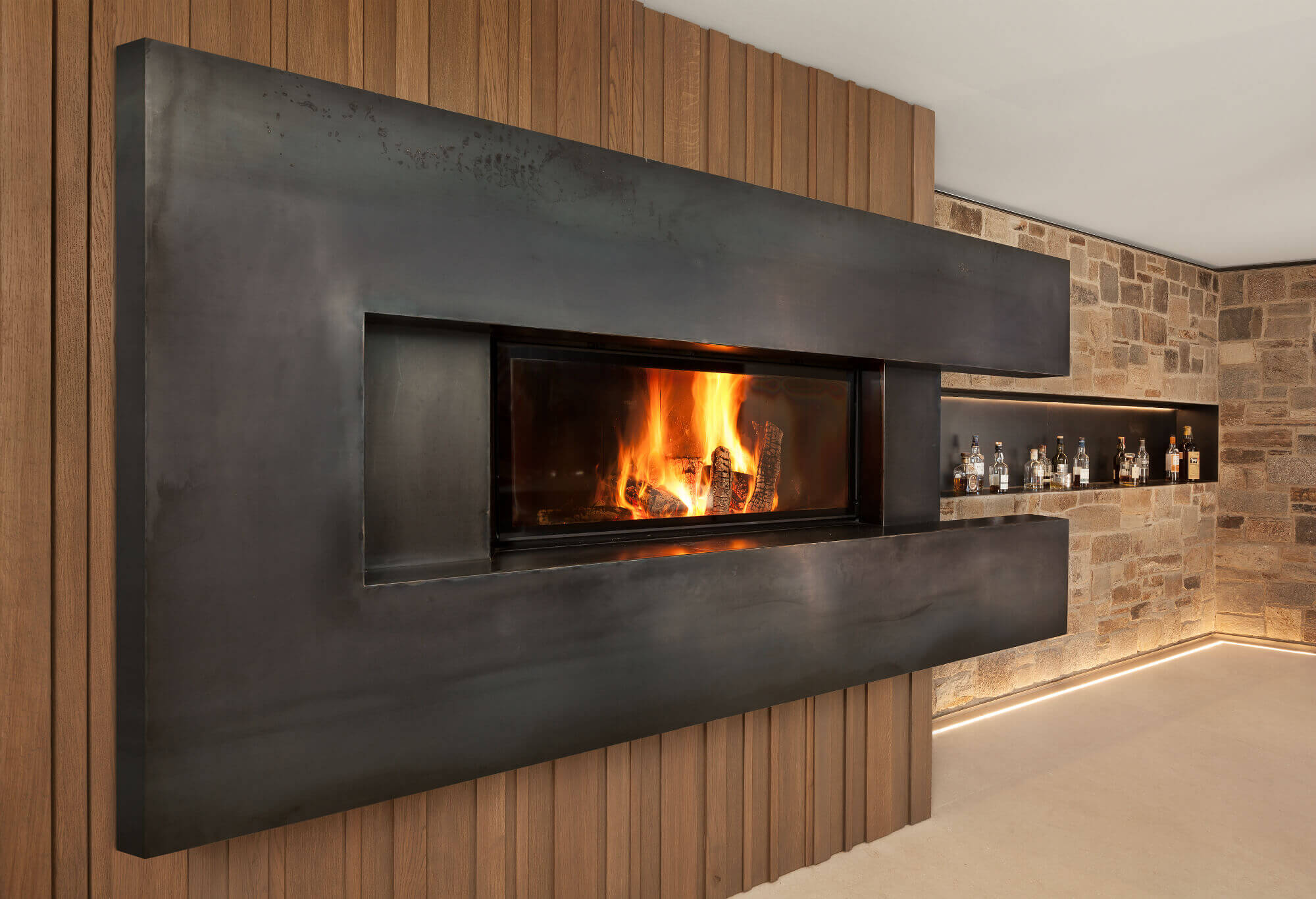 Weiße Kochinsel in einer großzügigen Wohnküche mit Essbereich und Kamin