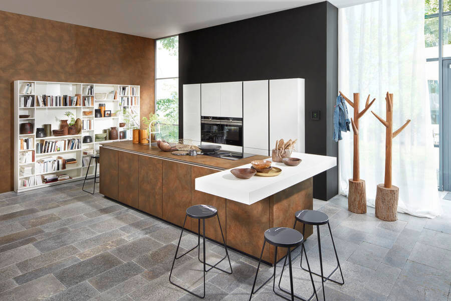 Moderne Küche mit Kochinsel und Fronten aus Metall (Nolte Küchen Fronten "Ferro Cortenstahl" und "Nova Lack Weiß"). Foto: Nolte
