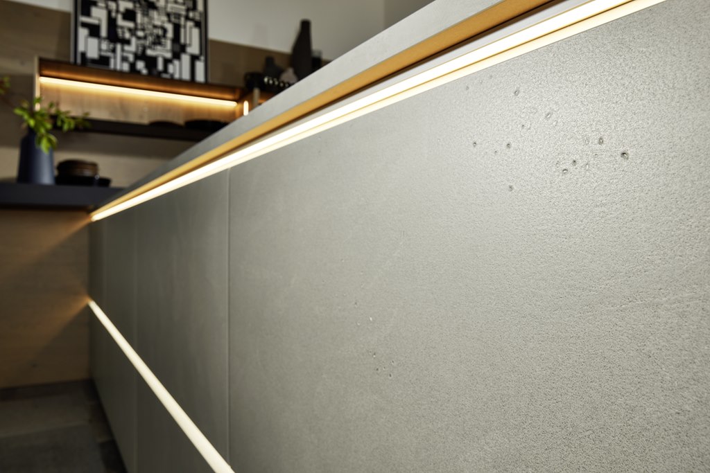 Grifflose Küche von nolte in Beton-Optik mit modernen, beleuchteten Griffmulden. Foto: nolte