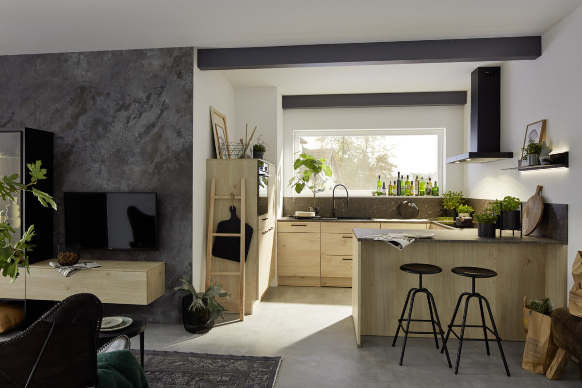 Durch die Verwendung der ARTWOOD Front auch im Wohnzimmer wird eine harmonische Überleitung in die Küche geschaffen.