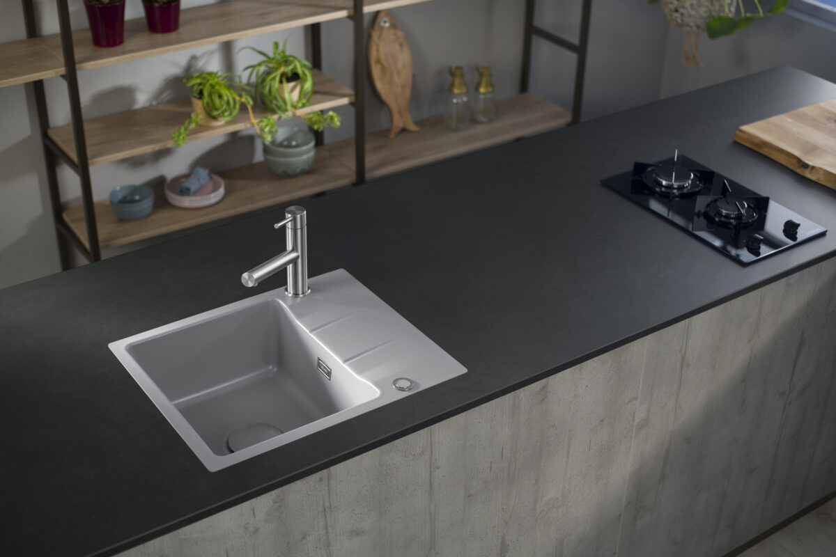 Systemceram-Keramikspüle in der Farbe Alu auf dunkler Arbeitsplatte, ideal für moderne Küchenstile.