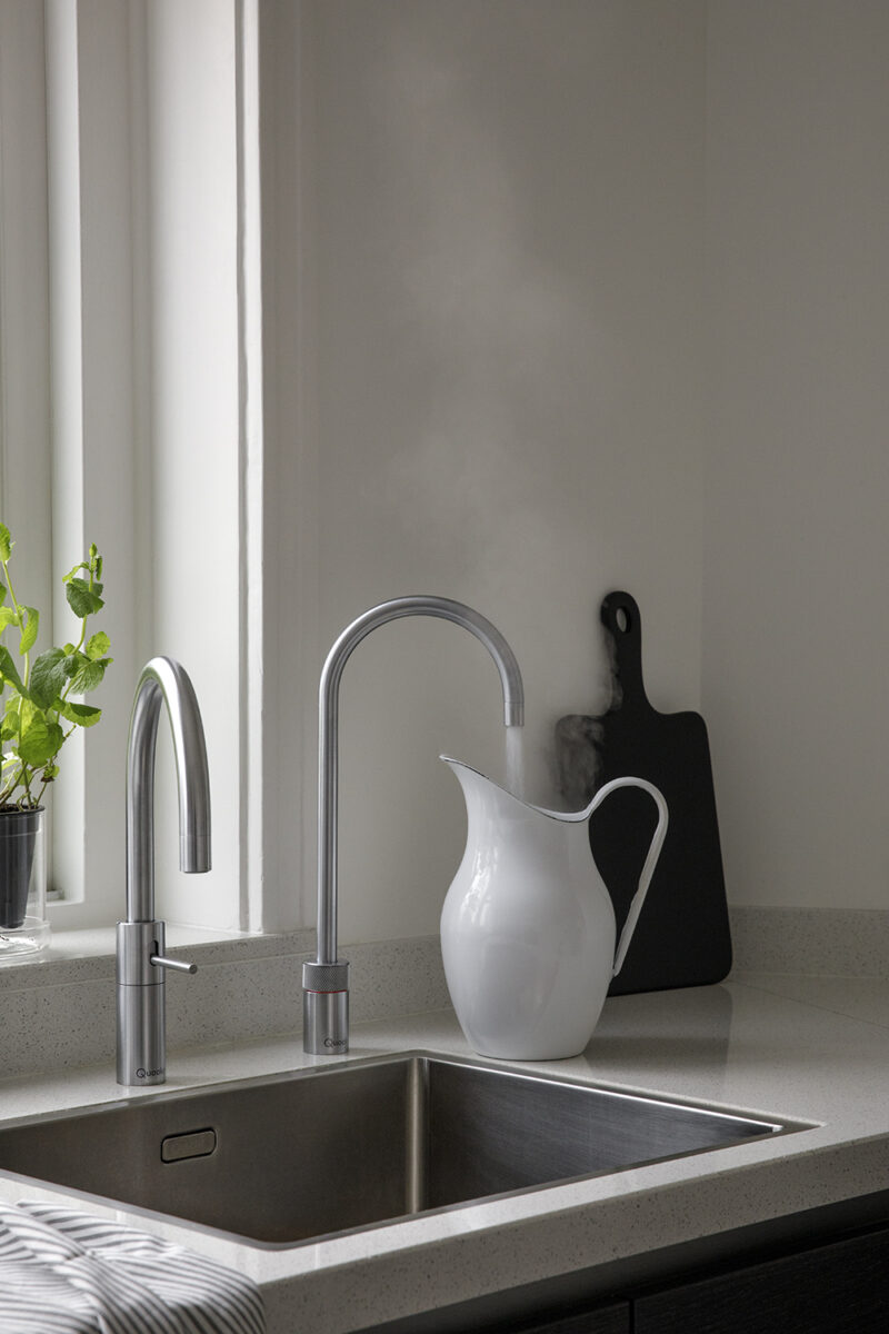 Zwei nebeneinander montierte Wasserhähne: links ein klassischer Einhebelmischer, rechts ein Quooker mit Dampf-Funktion. Eine elegante Kombination aus Komfort und Innovation.