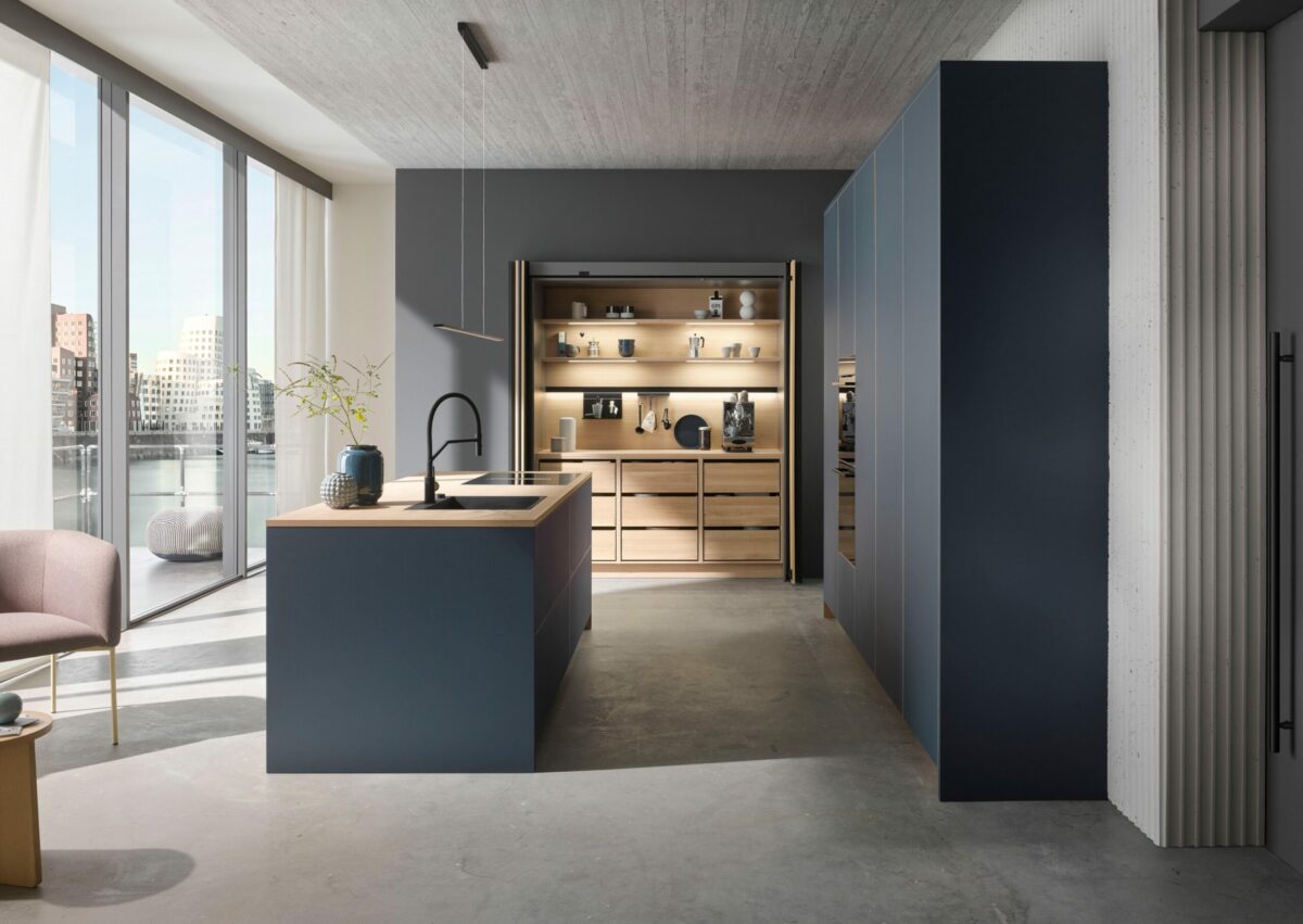 Wohnküche mit schwarzen Pocket Doors und nachhaltigen, rauchblauen Linoleum-Fronten aus natürlichen Rohstoffen.