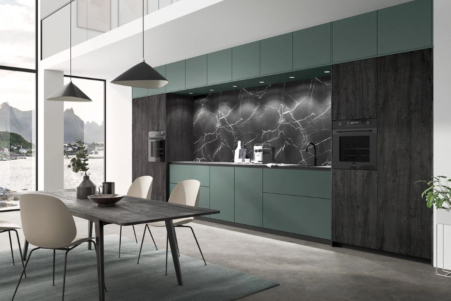 Innenaufnahme einer modernen Küche mit Holzfronten, Kochinsel und großer Glasfront. Helle Fenix-Oberflächen kombiniert mit Holz.