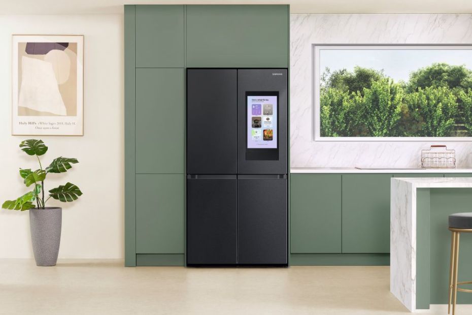Schwarzer Samsung Kühlschrank mit Smart Display in einer modernen Küche mit grüner Einbauwand und heller Arbeitsfläche.