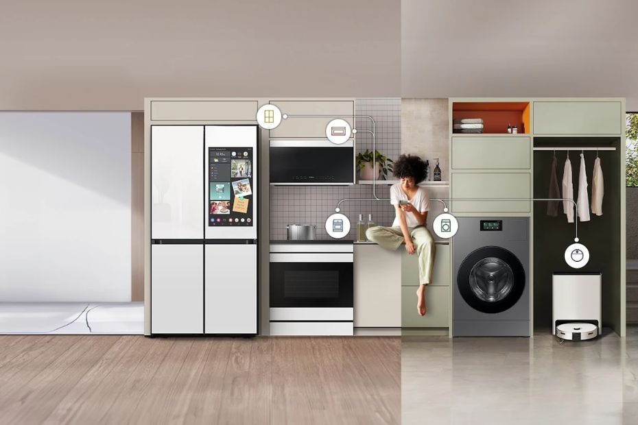 Frau sitzt in moderner Küche zwischen schwarzen Samsung Geräten, darunter Kühlschrank, Backofen und Waschmaschine.
