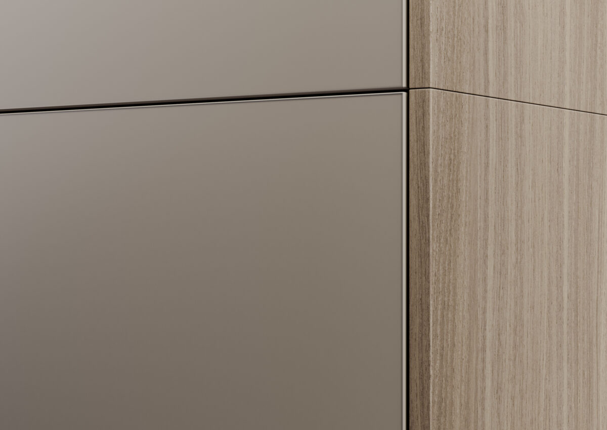 Nahaufnahme einer opaken, seidenmatten Küchenfront neben einer hellen Holzoberfläche.