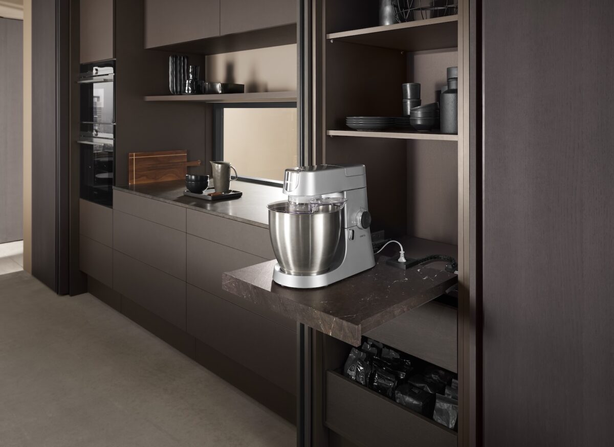 Ausziehbare Arbeitsfläche in einer modernen Küche mit integrierter AMPEROS-AC-Möbelsteckdose und einer angeschlossenen Küchenmaschine.