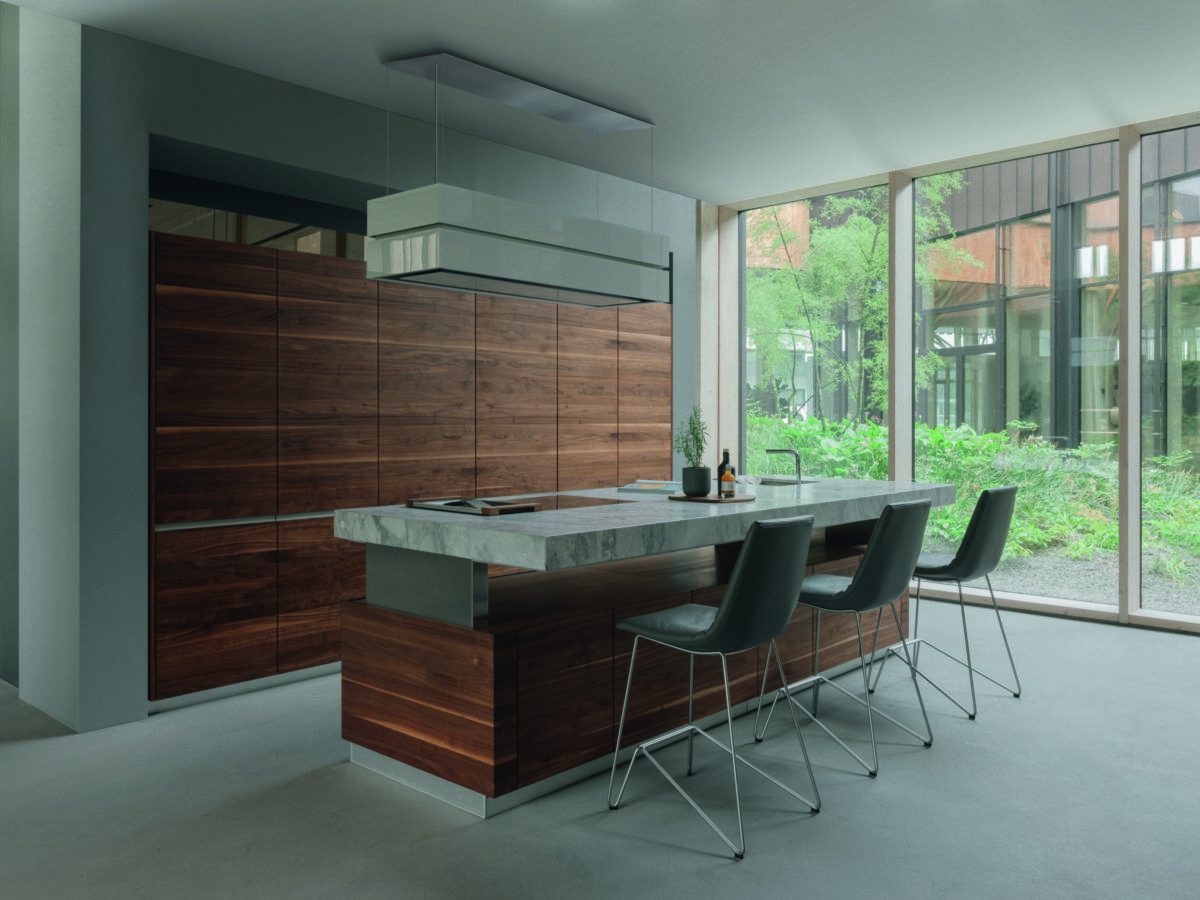 Kücheninsel mit Steinplatte und Fronten aus dunklem Holz, kombiniert mit klarer Linienführung.