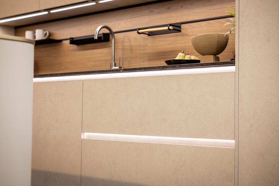Küchenzeile mit grifflosen Fronten, LED-Beleuchtung und Holzrückwand von Rotpunkt Küchen
