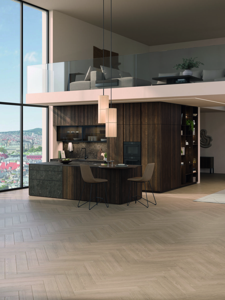 Dunkle Küchenzeile mit gegenüberliegender Regalwand und Esstisch