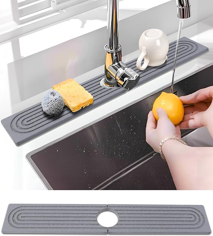 Graue schmale Kieselgur Abtropfplatte hinter Küchenarmatur mit Schwamm und Tasse gegen Kalkränder