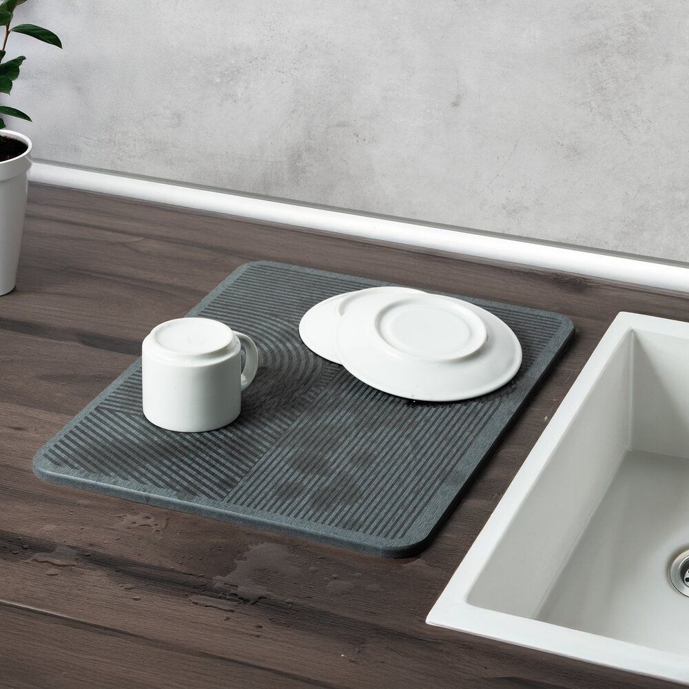Graue Kieselgur Abtropfmatte mit Tasse und Teller auf Holzarbeitsplatte neben weißer Küchenspüle