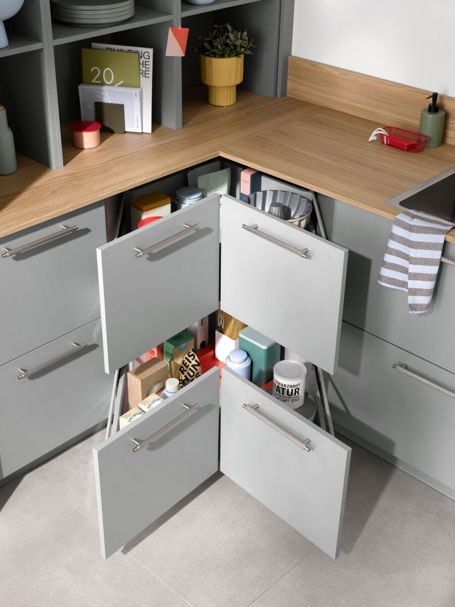 Eckschrank in einer kleinen Küche mit ausziehbarem Eckauszugssystem für Töpfe und Vorräte.