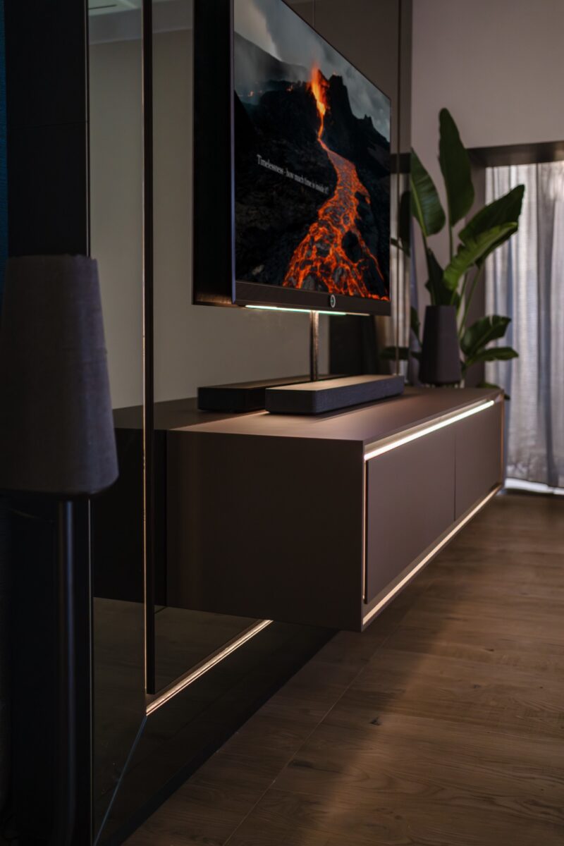 Modernes Sideboard mit indirekter Beleuchtung und dunklen matten Oberflächen in einer Wohnküche