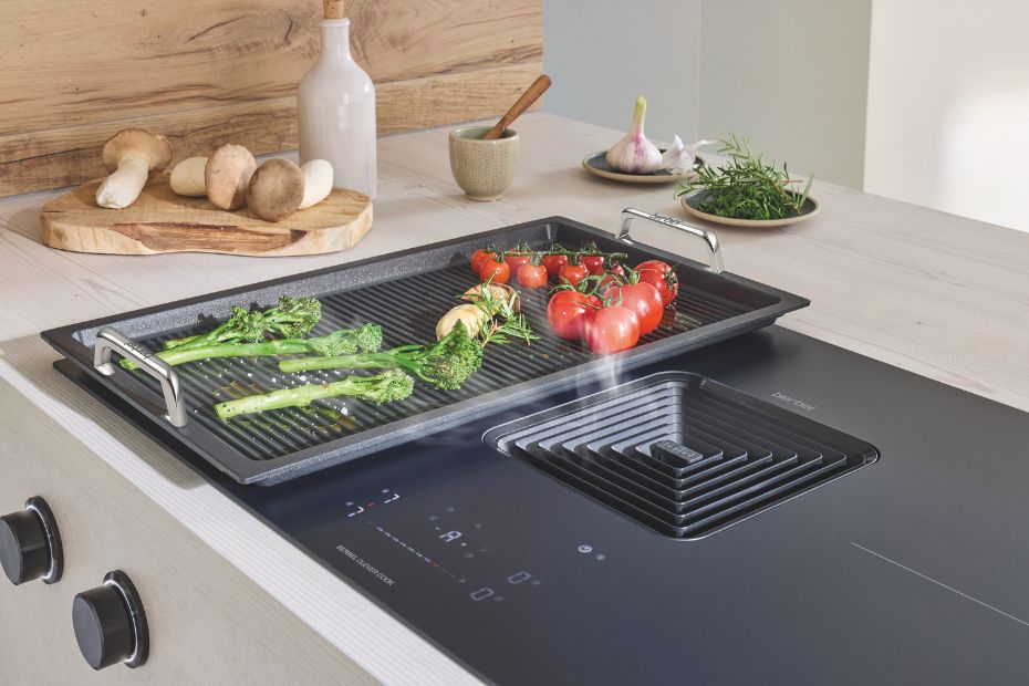 berbel Grillplatte MAX mit Gemüse auf Induktionskochfeld und integriertem Kochfeldabzug beim Indoor-Grillen in der Küche