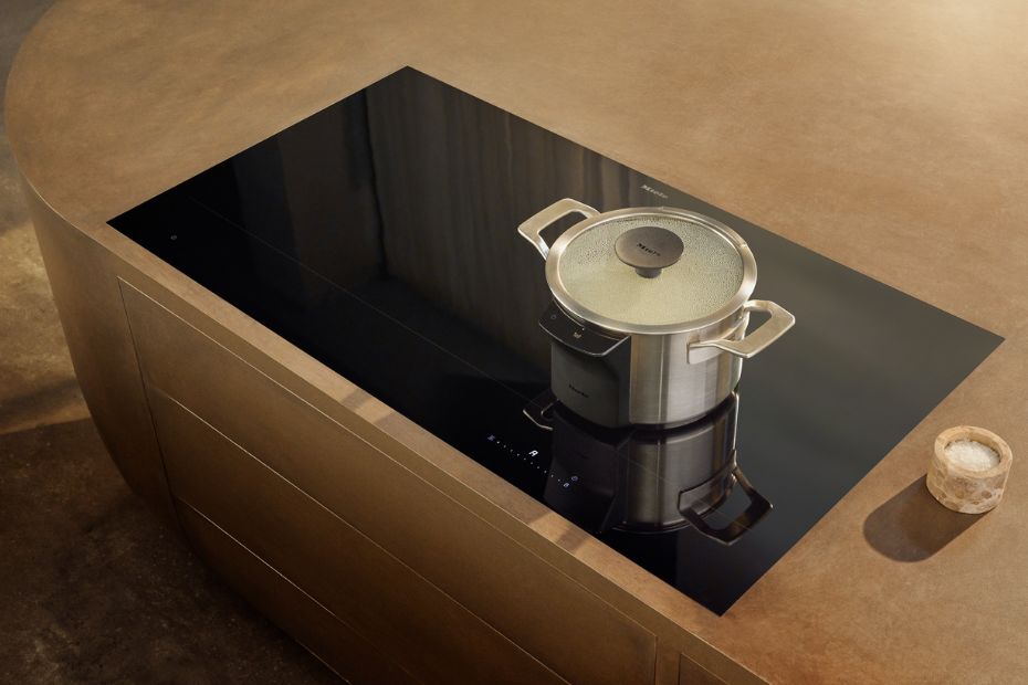Miele M Sense Topf mit Sensoreinheit auf schwarzem Induktionskochfeld in moderner Kücheninsel