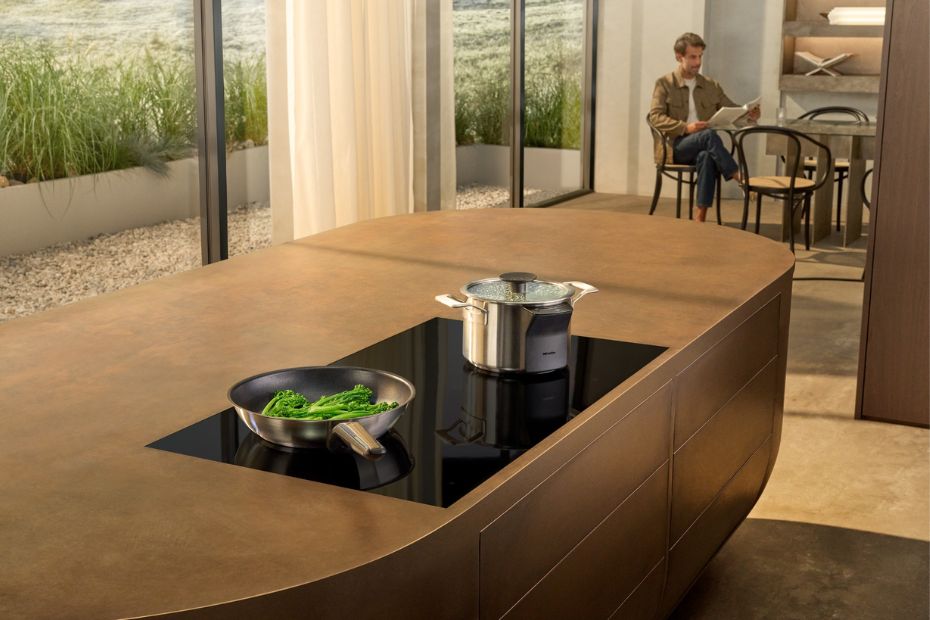 Moderne Kücheninsel mit flächenbündigem Miele Induktionskochfeld und Topf mit M Sense Sensor