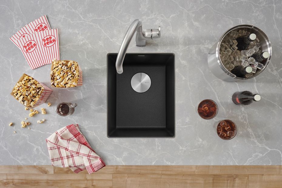 Kleine schwarze Spüle mit Armatur neben Popcorn, Getränken und Eiswürfeleimer