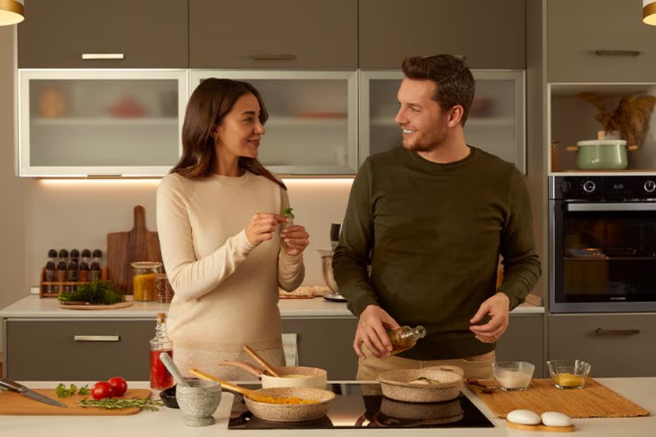 Zwei Personen kochen in moderner Küche mit Grundig Backofen und Kochfeld