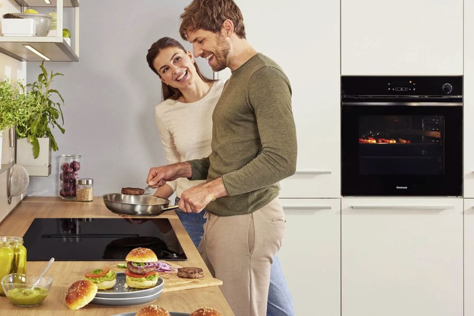 Moderne Küche mit Constructa Backofen, Kochfeld und Personen beim Kochen
