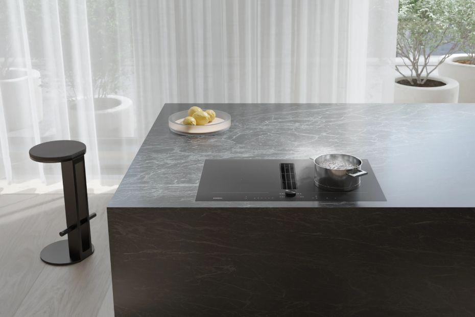 Gaggenau Kochfeld mit integriertem Dunstabzug auf dunkler Kücheninsel mit Topf