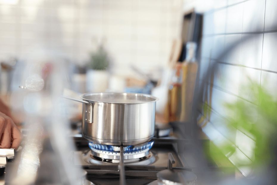Topf auf Gasflamme in heller Küche beim Kochen