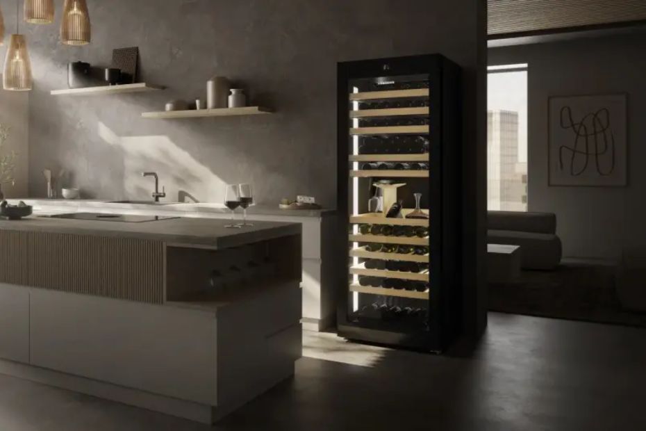 Hoher schwarzer Weinkühlschrank mit Glastür und beleuchteten Holzablagen neben einer Kücheninsel.